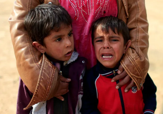 Displaced Iraqi boys cry after their father was killed by a mortar launched by Islamic State militants at Samah neighborhood during a fight between the militants and the Iraqi Counter Terrorism Service, in Mosul, Iraq November 13, 2016. (Photo by Ahmad Jadallah/Reuters)
