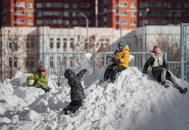 Children play in the snow after a snowfall in Moscow, Russia, 15 February 2021. Moscow was struck by a powerful snowfall, and temperatures​ in the Russian capital dropped to minus 18 degrees Celsius. (Photo by Yuri Kochetkov/EPA/EFE)