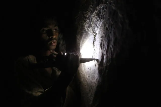 A gold mine worker looks for gold inside a local mine in Al-Ibedia locality at River Nile State, July 30, 2013. (Photo by Mohamed Nureldin Abdallah/Reuters)