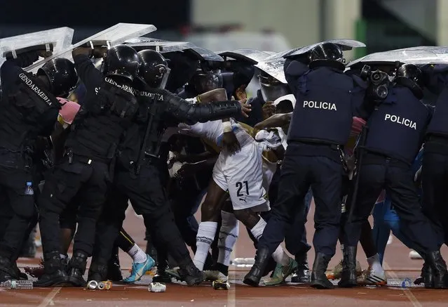 Riot police shield Ghana's John Boye (21) and team mates from objects thrown by Equitorial Guinea fans at the end of the first half of the 2015 African Cup of Nations semi-final soccer match in Malabo February 5, 2015. (Photo by Amr Abdallah Dalsh/Reuters)