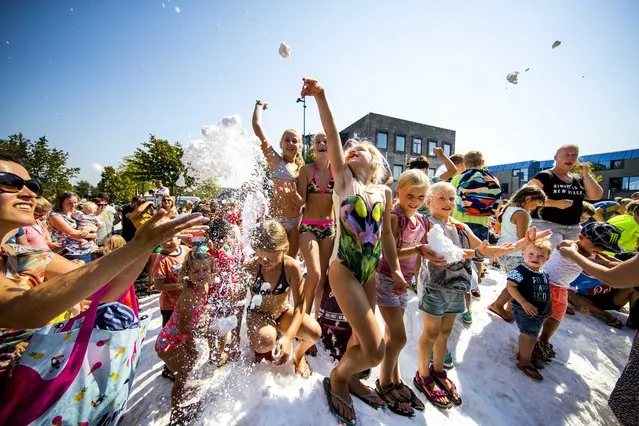 Children enjoy snow during a hot and sunny day in Best, The Netherlands, on August 3, 2018. A local juice maker gives coolness with snow cannons during the heat wave. (Photo by Jerry Lampen/EPA/EFE/Rex Features/Shutterstock)