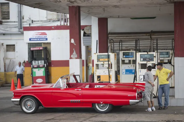 A vintage car is filled with fuel at a gas station along the seafront boulevard El Malecon in Havana, January 2015. (Photo by Alexandre Meneghini/Reuters)