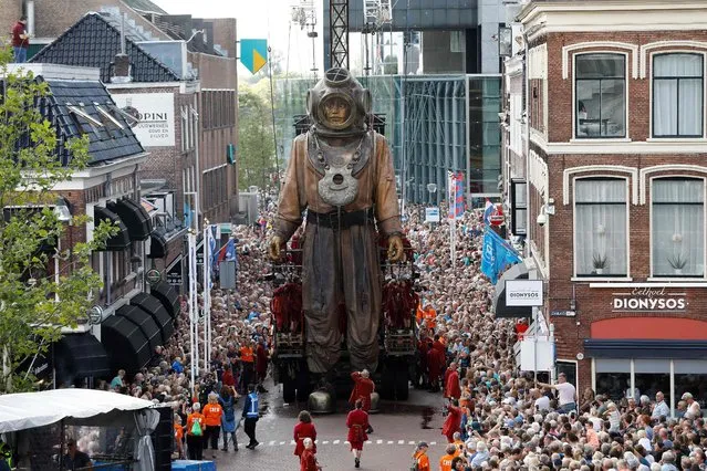 An animated marionette, a so-called Giant, of French street theatre company Royal de Luxe parades through the streets in the European Capital of Culture 2018, Leeuwarden, The Netherlands, on August 17, 2018. Royal de Luxe present a new story based on the saga of the Giants called “Grand patin dans la glace” (Big skate on the ice) during three days until August 19, 2018. (Photo by Bas Czerwinski/AFP Photo)