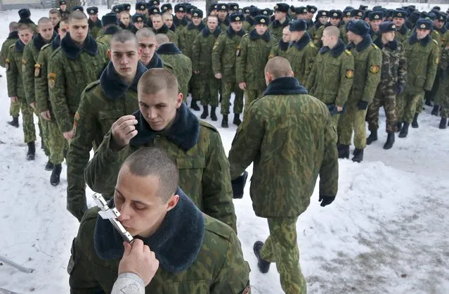 Servicemen of the Belarus Interior Ministry's special unit lineup to kiss an Orthodox cross after an Orthodox Christmas service at their military base in Minsk, Belarus, Thursday, January 7, 2016. Belarus Orthodox believers celebrate Christmas by the Julian calendar on January 7. (Photo by Sergei Grits/AP Photo)