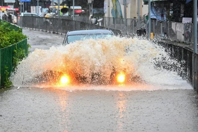 A motorist drives through floodwaters on Lantau Island in Hong Kong on September 8, 2023. Record rainfall in Hong Kong caused widespread flooding in the early hours on September 8, disrupting road and rail traffic just days after the city dodged major damage from a super typhoon. (Photo by Peter Parks/AFP Photo)