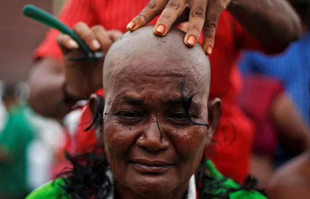 A supporter of Tamil Nadu Chief Minister Jayalalithaa Jayaraman gets her head shaved near Jayalalithaa's burial site in Chennai, India, December 7, 2016. (Photo by Adnan Abidi/Reuters)