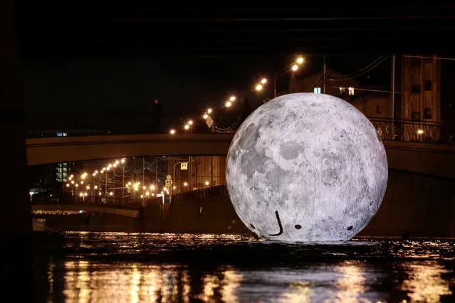 A giant ball decorated with images of the moon's surface, an installation for the “Festival of Lights”, is seen in the water of Obvodny channel in Saint Petersburg, Russia November 3, 2018. (Photo by Anton Vaganov/Reuters)