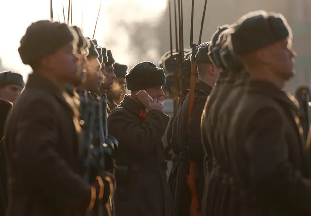 A participant speaks on the phone during preparations for a military parade to mark the anniversary of a historical parade in 1941, when Soviet soldiers marched towards the front lines during World War Two, in Red Square in Moscow, Russia November 7, 2018. (Photo by Maxim Shemetov/Reuters)