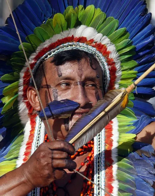 A member of indigenous group Kuikuro aims his arrow during the bow-and-arrow competition at the XII Games of the Indigenous People in Cuiaba November 10, 2013. 48 Brazilian Indigenous tribes will present their cultural rituals and compete in traditional sports such as archery, running with logs and canoeing during the XII Games of Indigenous People which will run until November 16. (Photo by Paulo Whitaker/Reuters)