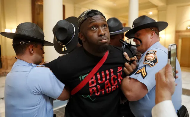 A man is arrested by Georgia state troopers during a protest over election ballot counts in the rotunda of the state Capitol building Tuesday, November 13, 2018, in Atlanta. Several protesters, including a state senator, have been arrested during a demonstration at the Georgia state Capitol calling for tallying of uncounted ballots from last week's election. (Photo by John Bazemore/AP Photo)