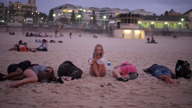 A girl waits for her friends to wake up after a night of New Year's Eve partying on Sydney's Bondi Beach before welcoming the first sunrise of 2017 in Australia's largest city, January 1, 2017. (Photo by Jason Reed/Reuters)