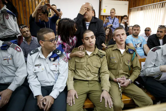 The father (back C) of Israeli soldier Elor Azaria (seated C), who is charged with manslaughter by the Israeli military after he shot a wounded Palestinian assailant as he laid on the ground in Hebron, prays behind him in a military court during a remand hearing for his case, near the southern Israeli city of Kiryat Malachi, March 31, 2016. The case has divided opinion in Israel. Many argue he must be punished for violating the military code of conduct. Others say his actions were justified. In their indictment, prosecutors said Sgt Azaria had “violated the rules of engagement without operational justification as the terrorist was lying on the ground wounded and represented no immediate threat”. (Photo by Amir Cohen/Reuters)