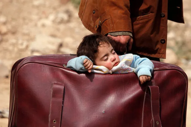 A child sleeps in a bag in the village of Beit Sawa, eastern Ghouta, Syria, March 15, 2018. (Photo by Omar Sanadiki/Reuters)
