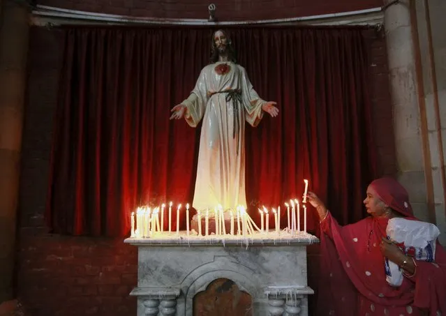 A Pakistani Christian woman lights a candle in front of a religious statue during Easter celebrations at the Sacred Heart of Jesus Church in Lahore April 5, 2015. (Photo by Mohsin Raza/Reuters)
