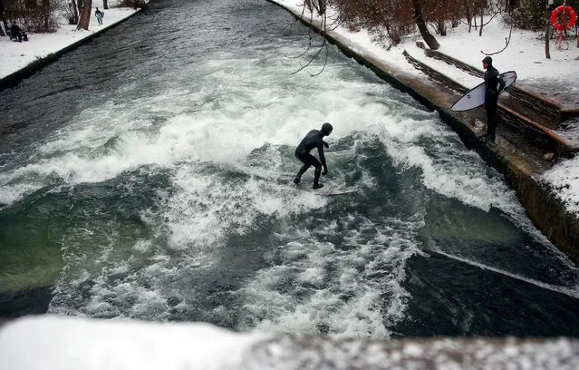 A surfer catches a wave on a freezing water of the Eisbach in Munich's famous English garden, Germany January 5, 2017. (Photo by Michael Dalder/Reuters)