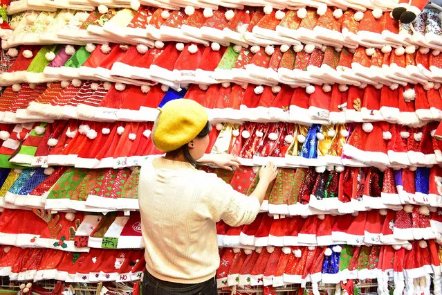 A vendor arranges Christmas hats on display for sale at the Yiwu International Trade City ahead of Christmas on December 17, 2018 in Jinhua, Zhejiang Province of China. (Photo by Lyu Bin/VCG via Getty Images)