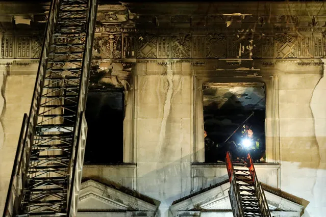 Fire crew work at the site of a fire at the Serbian Mission on Fifth Avenue on the Upper East Side of Manhattan in New York City, U.S., December 9, 2018. (Photo by Andrew Kelly/Reuters)