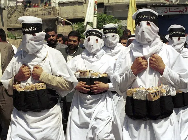 A group of hooded Hamas militants, wearing fake explosives on their waist and black headbands reading “Death for the sake of God”, march together during a demonstration in the southern port city of Tyre, Lebanon, April 13, 2001. (Phoot by Mohamed Zatari/AP Photo)