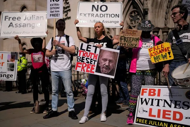 Supporters of WikiLeaks founder Julian Assange hold placards as they protest, during the first hearing in the Julian Assange extradition appeal, at the High Court in London, Wednesday, August 11, 2021. Britain's High Court has granted the U.S. government permission to appeal a decision that WikiLeaks founder Julian Assange cannot be sent to the United States to face espionage charges. (Photo by Matt Dunham/AP Photo)