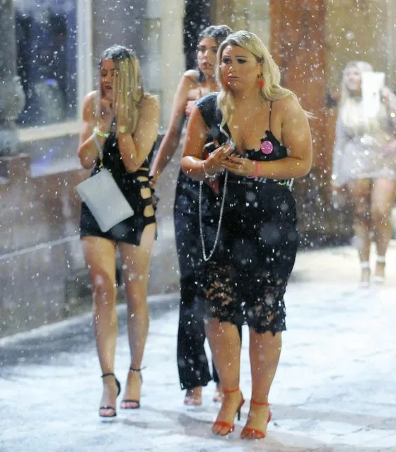 Three scantily clad pals make their way through the snow as it falls around them in Newcastle, England on February 1, 2019. (Photo by Will Walker/North News and Pictures)