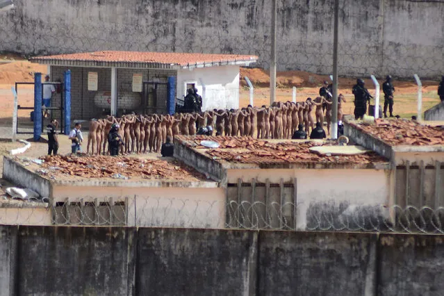 Naked inmates stand in line while surrounded by police after a riot at the Alcacuz prison in Nisia Floresta, Rio Grande do Norte state, Brazil, Sunday, January 15, 2017. Security authorities said Sunday they have regained control of two Brazilian prisons after several inmates were killed during a riot, the latest in a string of prison disturbances across the country. (Photo by Frankie Marcone/Futura Press via AP Photo)