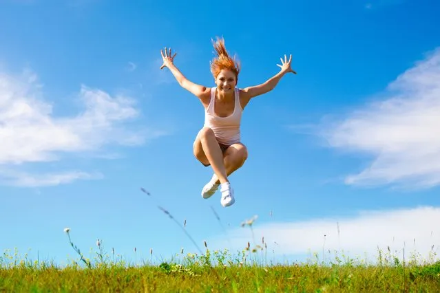 Young happy girl jumping on sunny meadow. (Photo by Rex Features/Shutterstock)