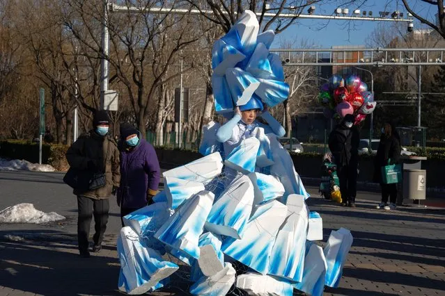 Chinese artiste Kong Ning wears her latest creation titled "Solidified Snow" to raise awareness of global warming in the coming new year in Beijing, Sunday, December 31, 2023. (Photo by Ng Han Guan/AP Photo)