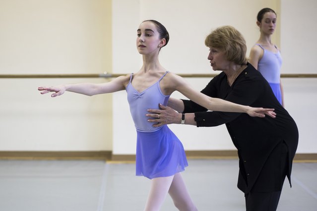 In this photo taken on Thursday, March 3, 2016, Tatyana Galtseva, a teacher of the Bolshoi Ballet Academy, right, helps Harper Ortlieb, from Mount Hood, Oregon, in a ballet class at the Bolshoi Ballet Academy in Moscow, Russia, Thursday, March 3, 2016. (Photo by Alexander Zemlianichenko/AP Photo)