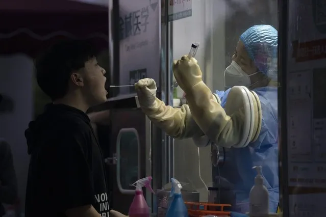 A man gets swapped during a nuclei test for COVID-19 in Beijing Saturday, September 18, 2021. China's "zero tolerance" strategy of trying to isolate every case and stop transmission of the coronavirus has kept kept the country where the virus first was detected in late 2019 largely free of the disease. (Photo by Ng Han Guan/AP Photo)
