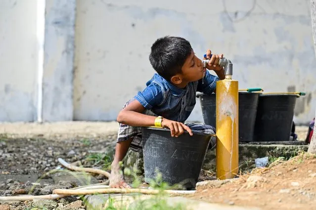A Rohingya refugee Child drinks from a water tap at a temporary shelter at a government building in Banda Aceh on January 11, 2024. (Photo by Chaideer Mahyuddin/AFP Photo)