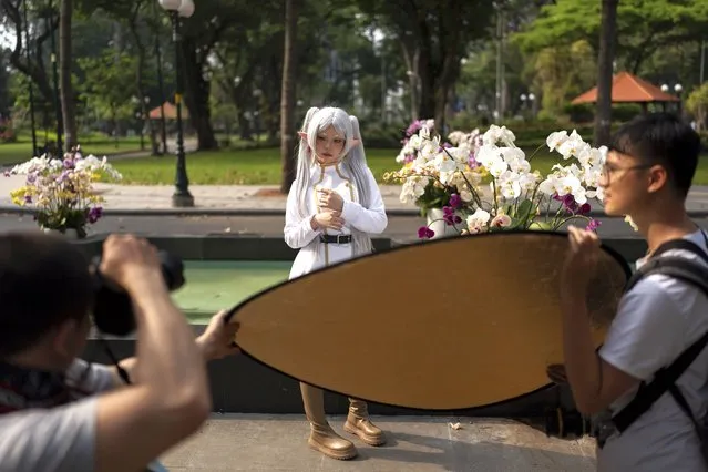 A woman dressed as a character poses for photos at a park in Ho Chi Minh City, Vietnam, January 14, 2024. (Photo by Jae C. Hong/AP Photo)