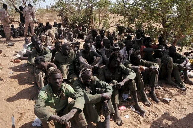 Justice and Equality Movement (JEM) rebels, who were captured after being defeated by the Sudanese Armed Forces (SAF) and the Rapid Support Forces (RSF), sit during a visit by Sudanese President Omar Hassan al-Bashir to the battle area of Gouz Dango in South Darfur April 28, 2015. (Photo by Reuters/Stringer)