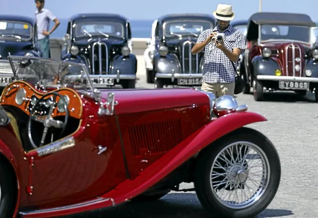 A man takes pictures of a MG classic car during the annual “British Car Day” celebrations in Colombo, Sri Lanka March 13, 2016. (Photo by Dinuka Liyanawatte/Reuters)