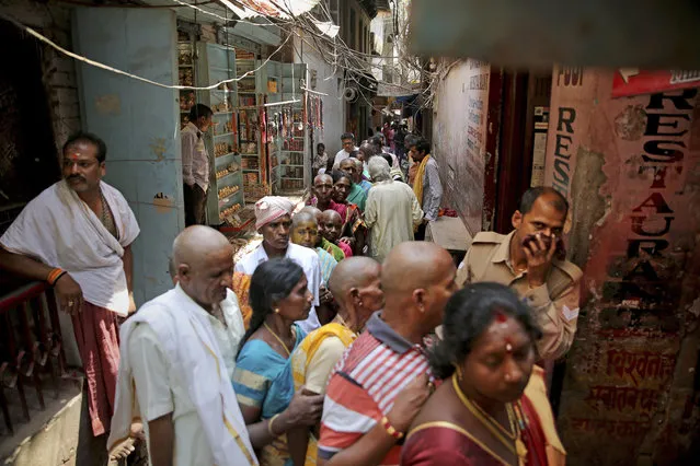 In this March 22, 2019, photo, Hindu devotees stand in queue in a narrow lane to enter into Vishwanath temple, in Varanasi, India. In the Indian city considered the center of the Hindu universe, Prime Minister Narendra Modi has commissioned a grand promenade connecting the sacred Ganges river with a centuries-old Vishwanath temple dedicated to Lord Shiva, the god of destruction. (Photo by Altaf Qadri/AP Photo)