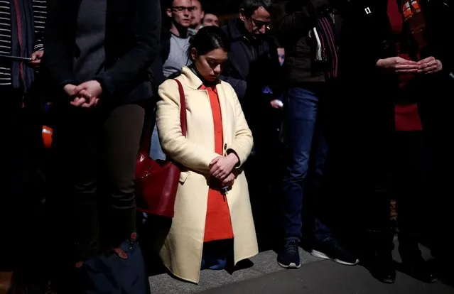 A woman prays next to Notre-Dame Cathedral in Paris on April 15, 2019. (Photo by Benoit Tessier/Reuters)