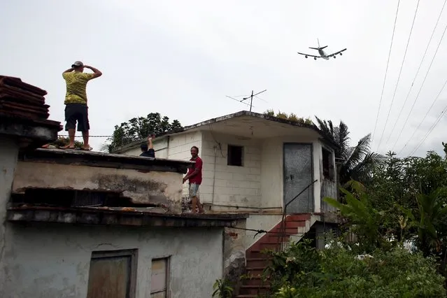 People look from the roof of a house as Air Force One carrying U.S. President Barack Obama and his family departs from the Jose Marti international airport in Havana, March 22, 2016. (Photo by Alexandre Meneghini/Reuters)