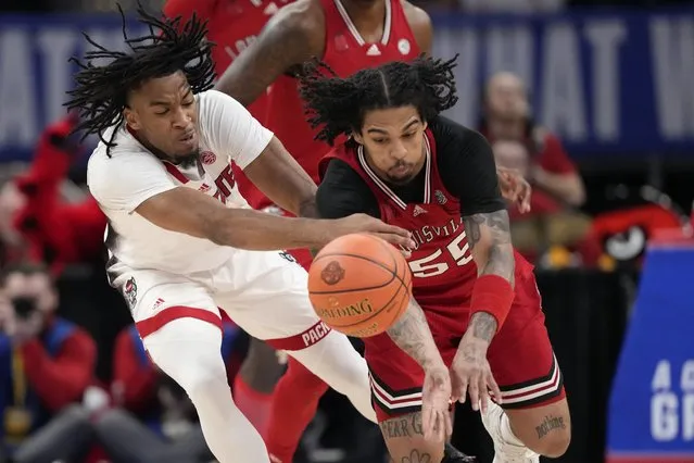 Louisville guard Skyy Clark (55) steals the ball from North Carolina State guard Jayden Taylor (1) during the first half of the Atlantic Coast Conference NCAA college basketball tournament, Tuesday, March 12, 2024, in Washington. (Photo by Alex Brandon/AP Photo)