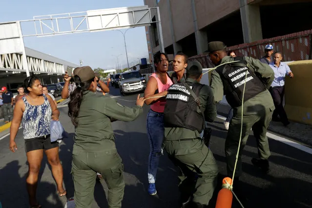 Venezuelan National Guards try to control opposition and pro-government supporters as they clash at Simon Bolivar airport after Lilian Tintor, wife of jailed Venezuelan opposition leader Leopoldo Lopez, arrived in Caracas, Venezuela February 16, 2017. (Photo by Marco Bello/Reuters)