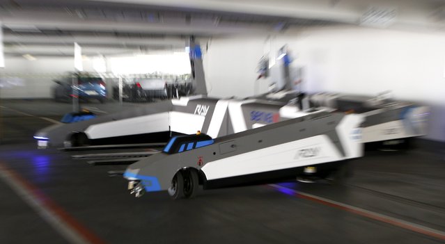 Automated guided vehicle robot “Ray” prepares to lift up an Audi car during a pilot project at the parking area of the Audi plant in Ingolstadt, Germany, May 13, 2015. (Photo by Michaela Rehle/Reuters)