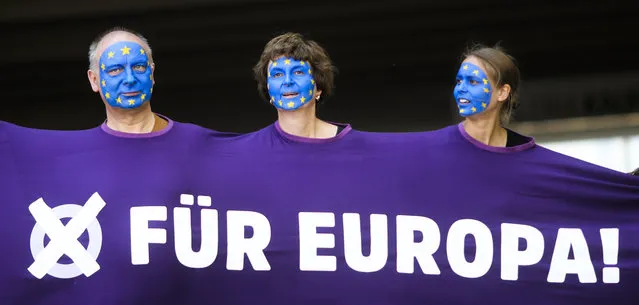 People, with faces painted like a European flag, arrive for a demonstration in Berlin, Germany, Sunday, May 19, 2019. People across Europe attend demonstrations under the slogan “A Europe for All – Your Voice Against Nationalism”. The banner reads “For Europe”. (Photo by Markus Schreiber/AP Photo)