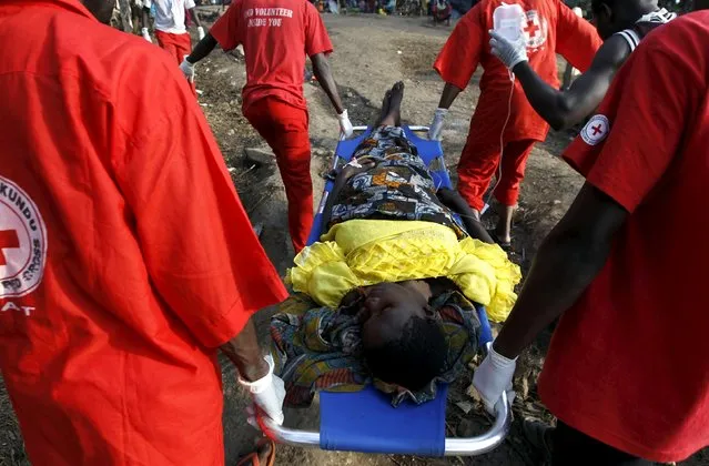 A sick Burundian refugee is carried by paramedics for treatment from her makeshift shelter on the shores of Lake Tanganyika in Kagunga village in Kigoma region in western Tanzania, as they wait for MV Liemba to transport them to Kigoma township, May 17, 2015. (Photo by Thomas Mukoya/Reuters)