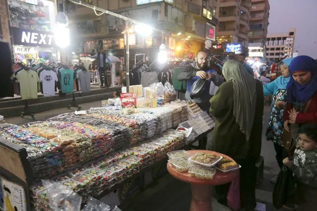 A Syrian street vendor sells sweets in an area called 6 October City in Giza, Egypt, March 19, 2016. Attracting visitors from across the country, a market mostly run by Syrians fleeing the war has recently gained popularity in Giza. (Photo by Mohamed Abd El Ghany/Reuters)