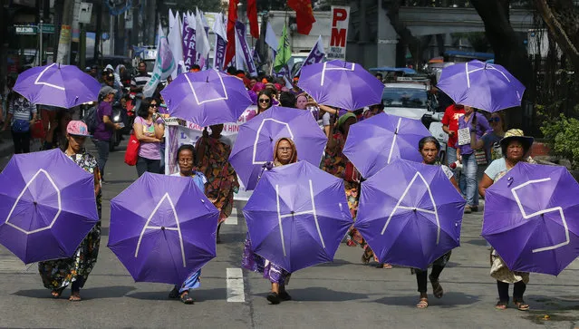 Women march during a rally marking International Women's Day, Wednesday, March 8, 2017, in Manila, Philippines. Women all over the world mark the women's day with protests and rallies to highlight the role of women in society. In the Philippines, the protesters urged President Rodrigo Duterte to address the pressing problems of lack of food, jobs and peace instead of killings and violence. (Photo by Bullit Marquez/AP Photo)