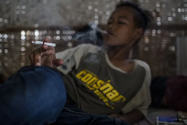 Candra (12), smokes at a kiosk on March 6, 2017 in Yogyakarta, Indonesia. (Photo by Ulet Ifansasti/Getty Images)