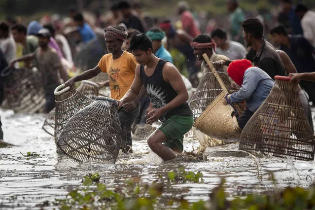 Villagers participate in community fishing as part of Bhogali Bihu celebrations in Panbari village, some 50 kilometers (31 miles) east of Gauhati, India, Thursday, January 13, 2022. (Photo by Anupam Nath/AP Photo)
