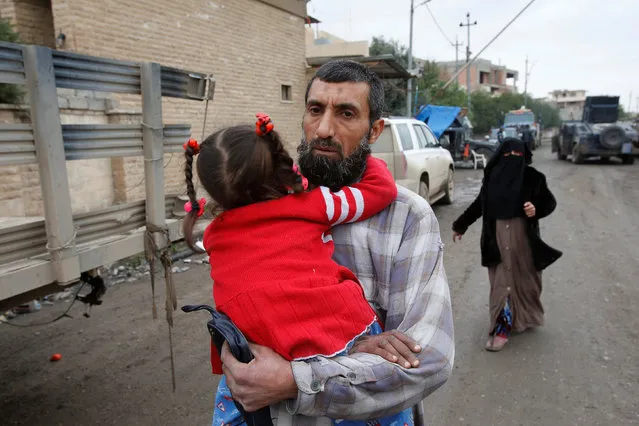 Displaced Iraqi people from the Bab al-Tob area in Mosul flee their homes after clashes to reach safe areas as Iraqi forces battle with Islamic State militants in the city of Mosul, Iraq, March 15, 2017. (Photo by Youssef Boudlal/Reuters)