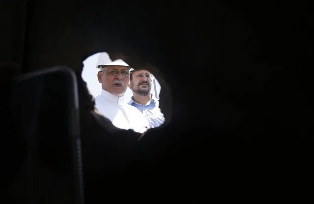 In this photo opportunity during a trip organized by Saudi information ministry, Aramco workers are seen through a hole in a damaged pipe in the Khurais oil field in Khurais, Saudi Arabia, Friday, September 20, 2019, after it was hit during Sept. 14 attack. Saudi officials brought journalists Friday to see the damage done in an attack the U.S. alleges Iran carried out. (Photo by Amr Nabil/AP Photo)