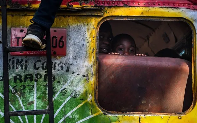 A boy peers from inside a bus in the Haitian capital Port-au-Prince, on April 5, 2019. (Photo by Chandan Khanna/AFP Photo)