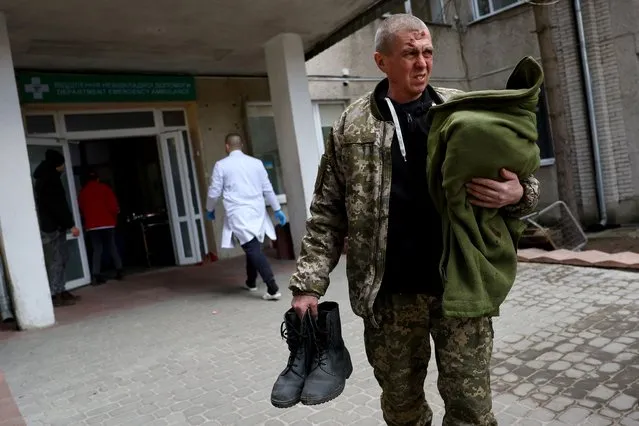 A serviceman looks on in front of a hospital following an attack on the Yavoriv military base, amid Russia's invasion of Ukraine, in Yavoriv, Ukraine, March 13, 2022. (Photo by Kai Pfaffenbach/Reuters)