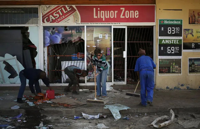 Locals clean up after over-night looting, when protesters took to the streets to demonstrate the killing of a boy in Coligny, North West province, South Africa, April 26, 2017. (Photo by Siphiwe Sibeko/Reuters)
